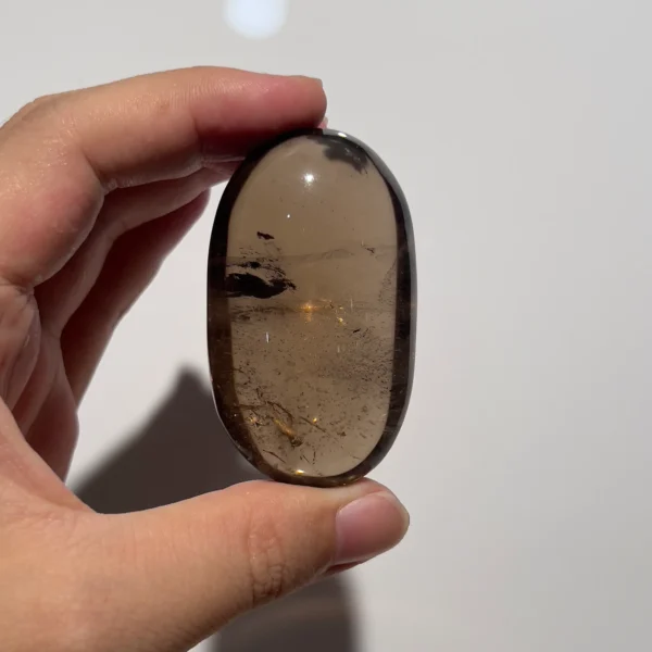 天然茶晶把玩側面照，可見晶面與礦皮
