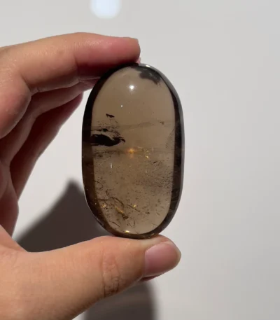 天然茶晶把玩側面照，可見晶面與礦皮